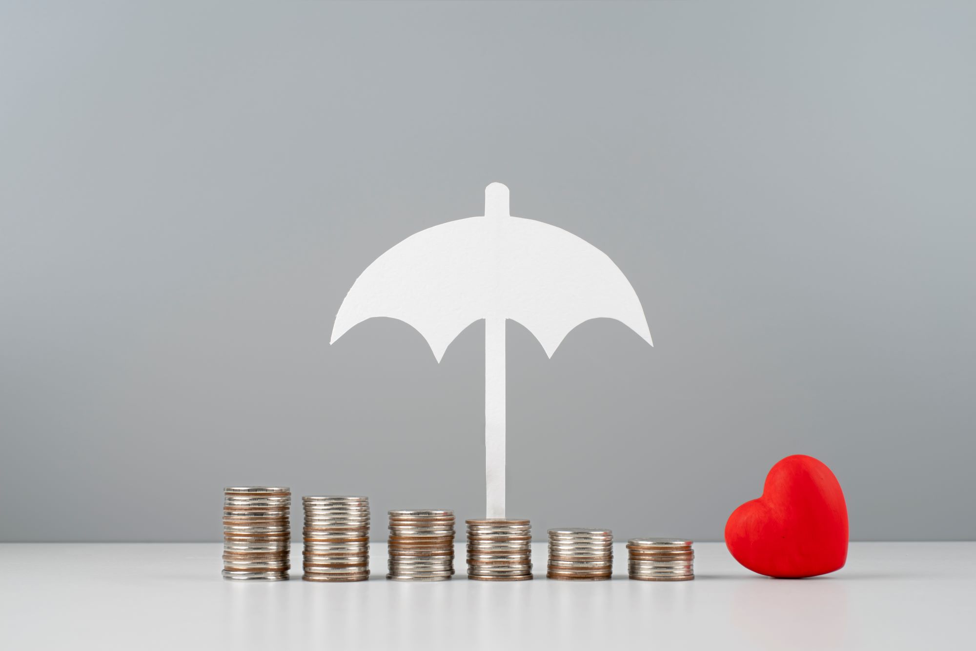 Paraguas protegiendo dinero y corazón
